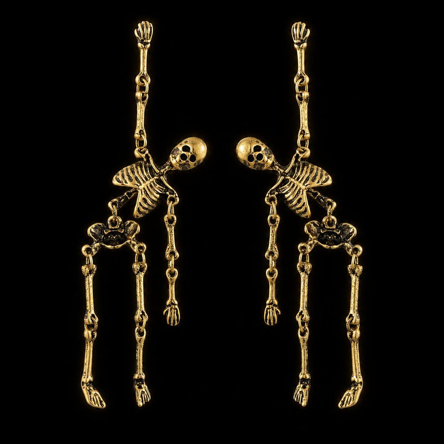 Skeleton dangle earrings in antiqued gold, shown as a pair on black